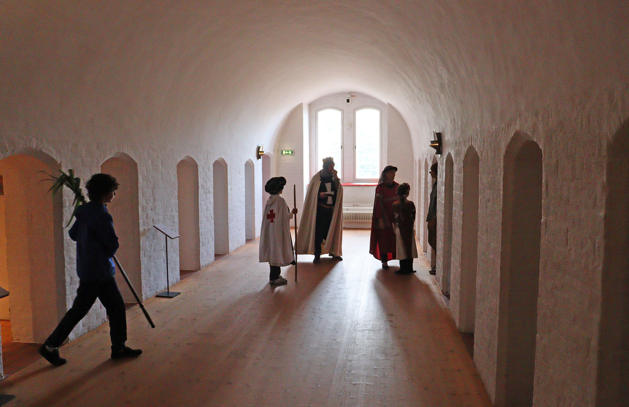 Interiör från klostermuseet med besökare utklädda i medeltid kläder. 