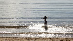 Barn som badar vid stranden