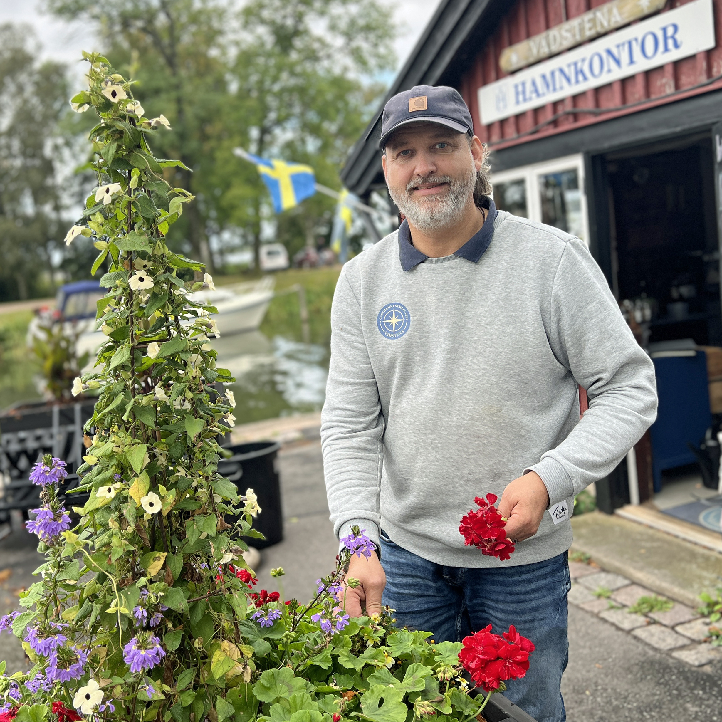 Johan Lindell vid blommorna framför hamnkontoret
